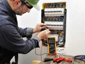 an electrician testing the performance of an electrical panel 